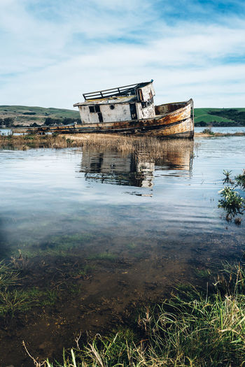 Shipwreck in water against sky