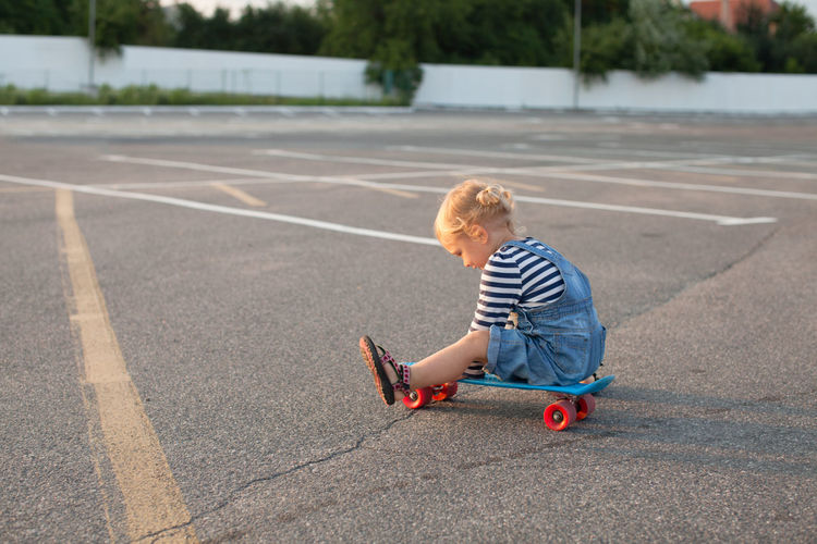 Full length of girl sitting on skateboard