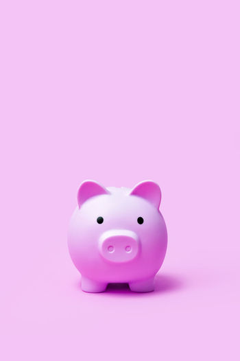 Close-up of piggy bank against pink background
