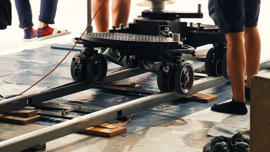 Low section of people standing by machine on track
