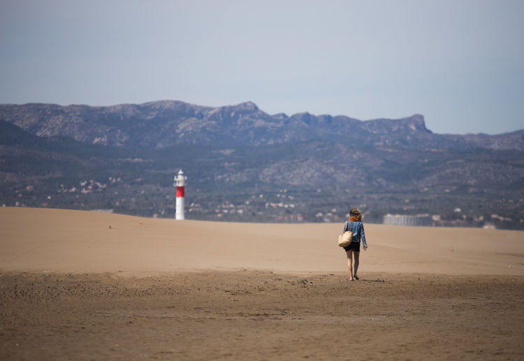 Rear view of woman walking on beach