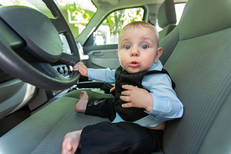 Portrait of cute boy sitting in car