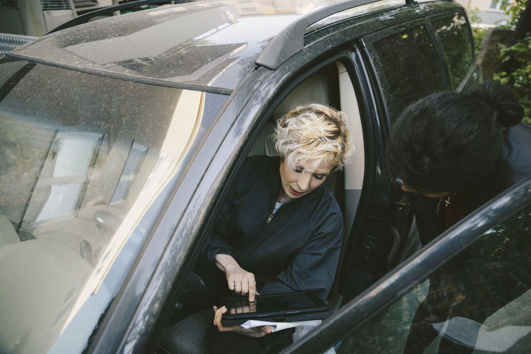 Woman sitting in car window