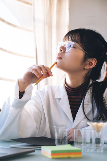 Young woman drinking water in laboratory