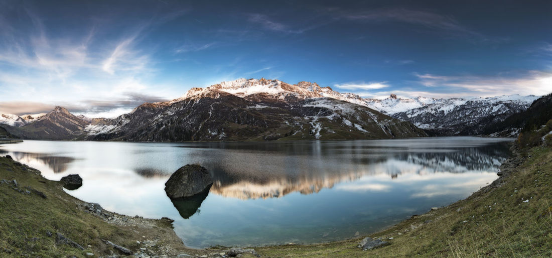 Scenic view of lake and snowcapped mountains against sky