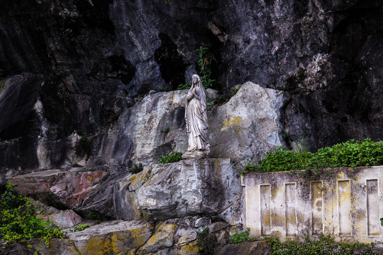 Statue of mother mary on rock