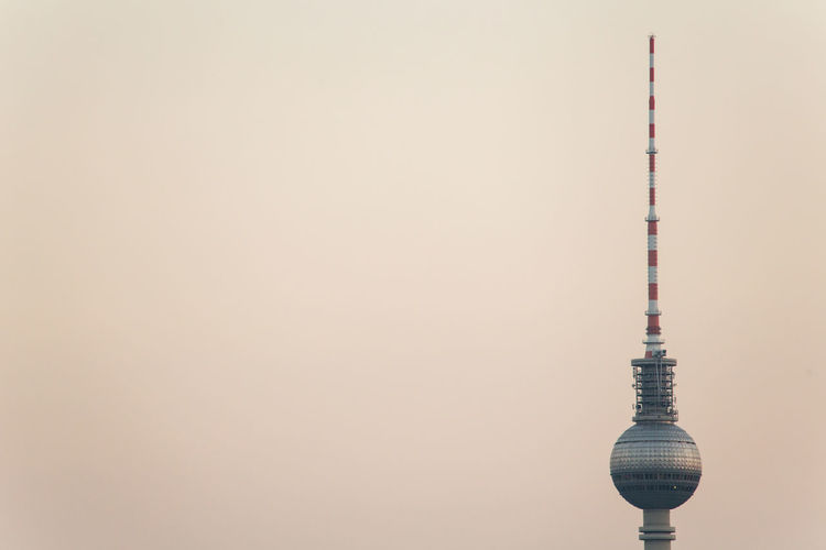 High section of fernsehturm television tower against clear sky during sunset