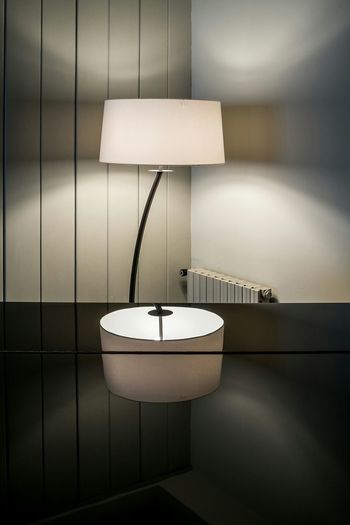 Illuminated lamp on table at home