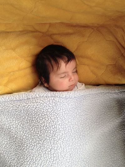 High angle view of baby sleeping in bed