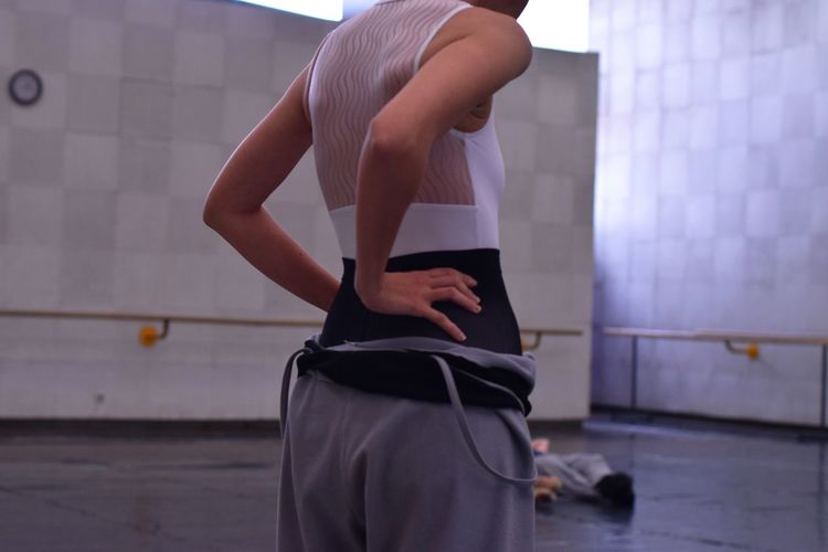 Midsection of ballerina practicing in ballet studio