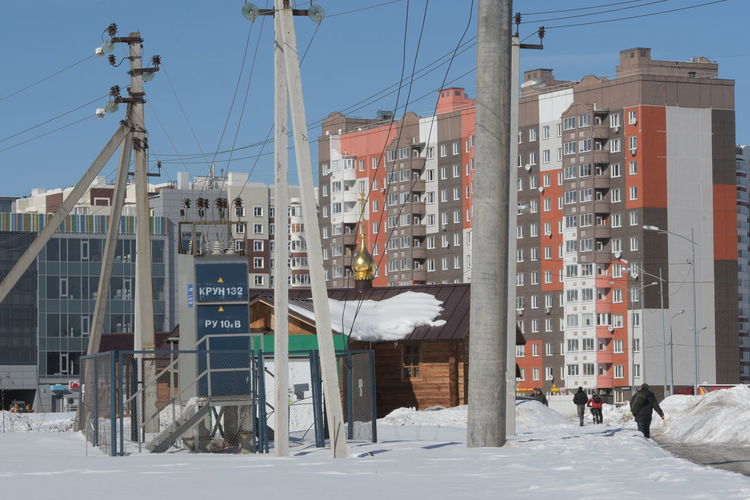 Buildings in city against clear sky during winter