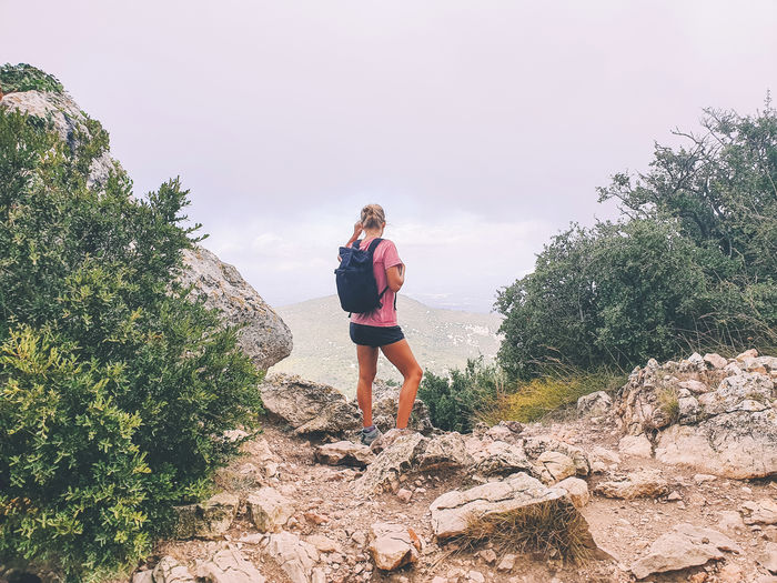 Female hiker standing next to the rock