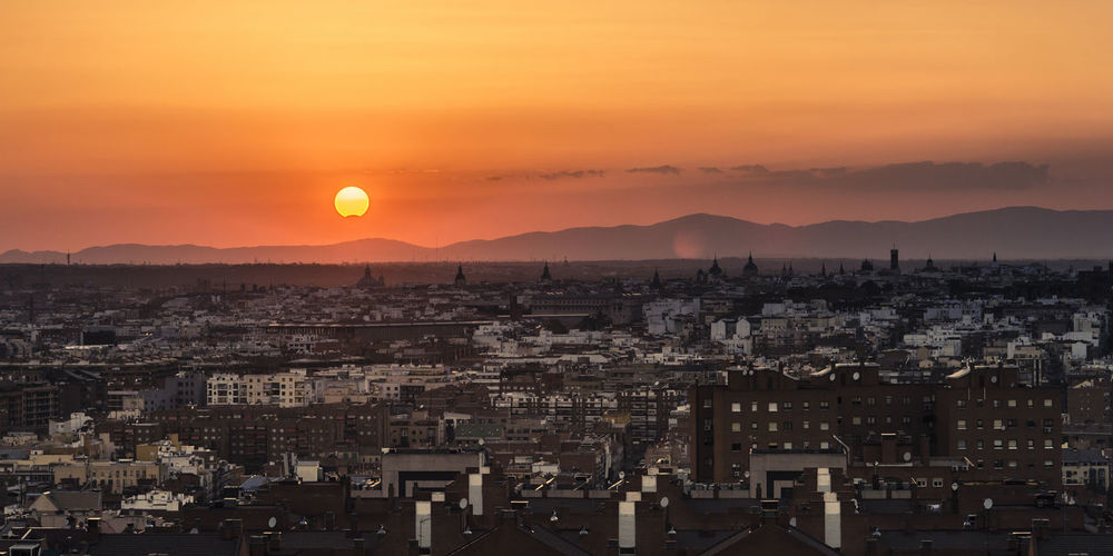 Partial sun eclipse over madrid skyline on a warm summer sunset
