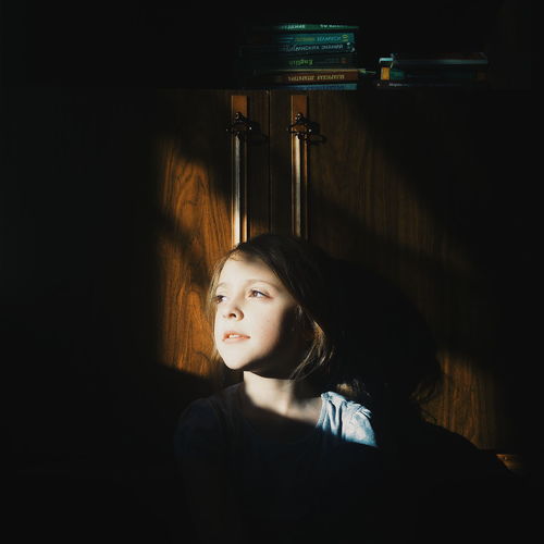 Thoughtful girl sitting in darkroom