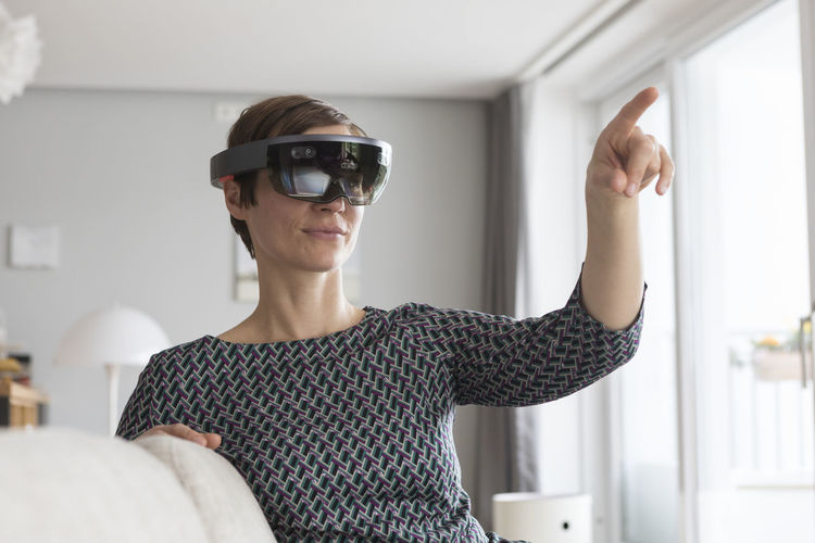 Woman at home using augmented reality glasses at home