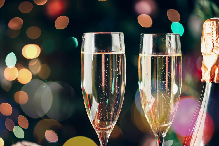 Two flute glasses and bottles of champagne in preparation for xmas or new year party.