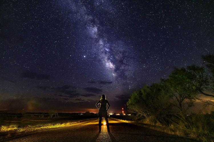 Man standing on field against sky at night