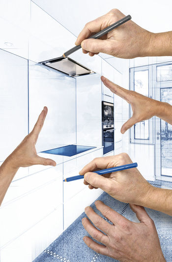 Cropped hands of interior designer designing kitchen