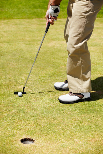 Low section of man playing golf