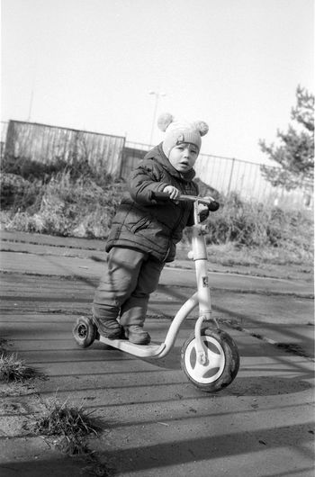 Portrait of boy riding motorcycle against clear sky