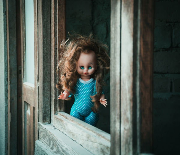 Portrait of cute girl looking through window
