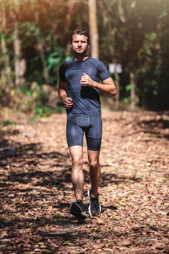 Full length portrait of man jogging in forest