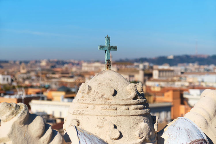 Rome, italy, world capital of christianity. rome panorama with a bronze cross on the foreground.