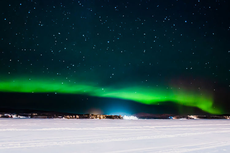 Aurora borealis over the frozen lake of inari in lapland