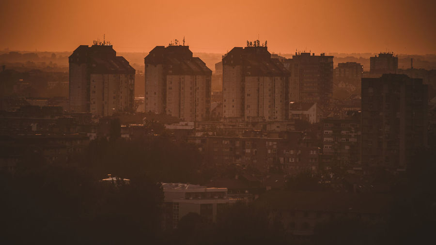 Buildings in city during sunset