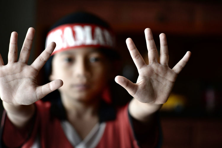 Portrait of boy showing stop gesture