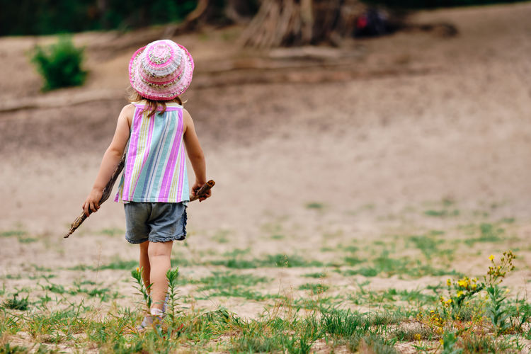 Rear view of girl walking on land