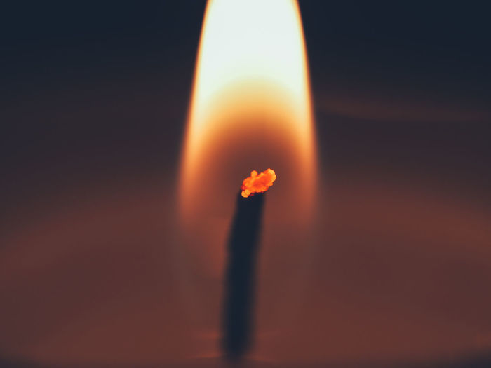 Close-up of lit candle against sunset