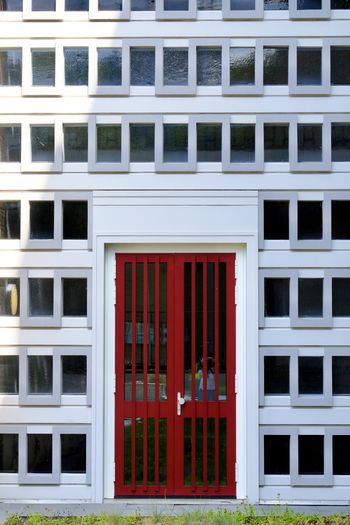 Full frame shot of building with red door and white facade.  