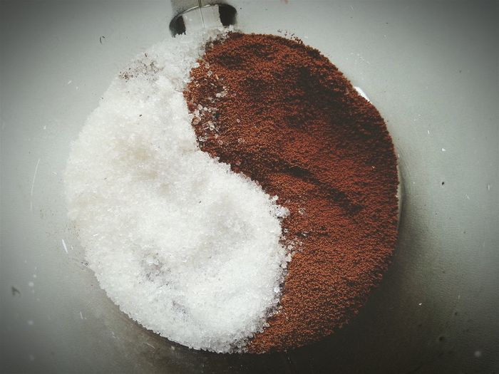 Directly above view of sugar and ground coffee arranged as yin yang symbol