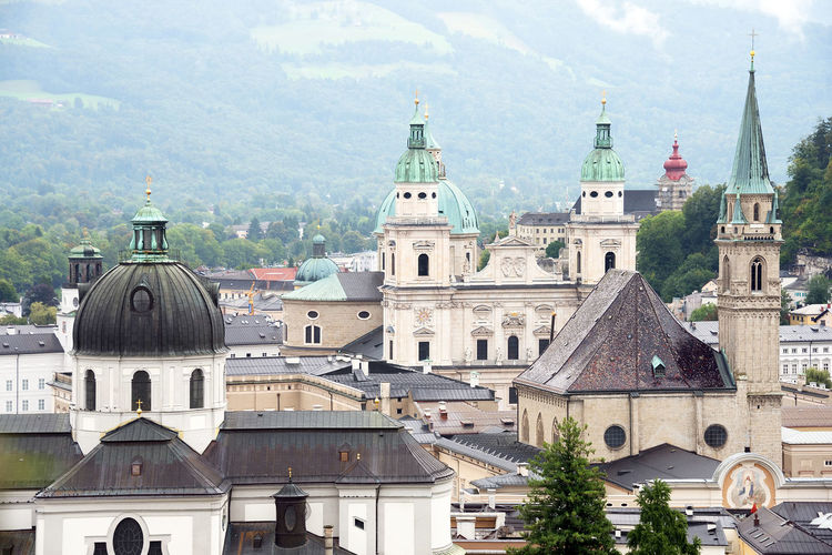 Collegiate church and salzburg cathedral amidst buildings in city
