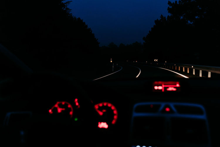 Road seen through car windshield at night