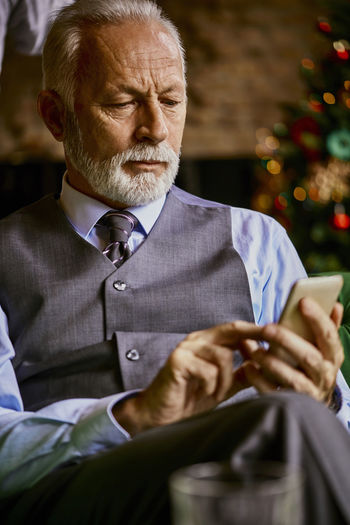 Elegant senior man using cell phone