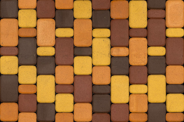 Seamless texture and background of brown and yellow artificial stone pavement