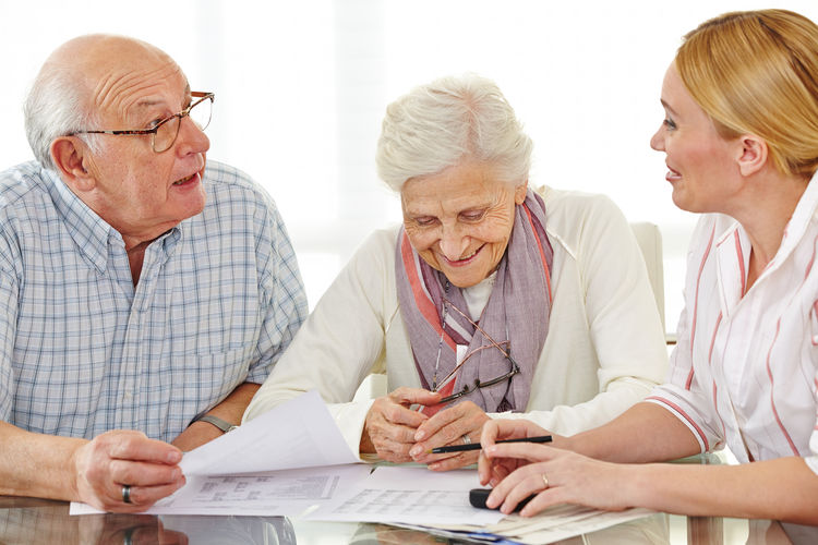 Senior couple talking with woman at home