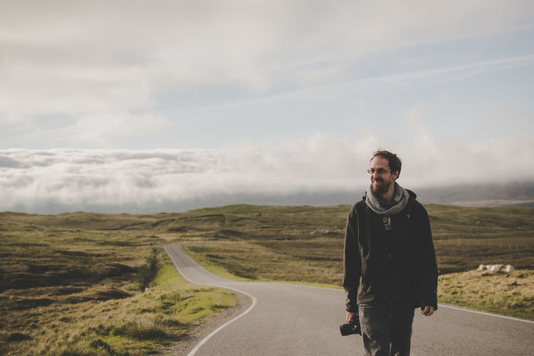 Man walking on road against sky