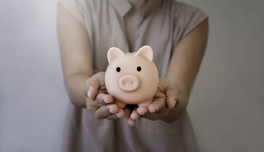 Midsection of woman holding piggy bank