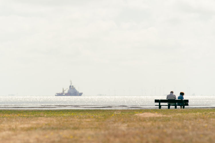 People sitting on bench in sea