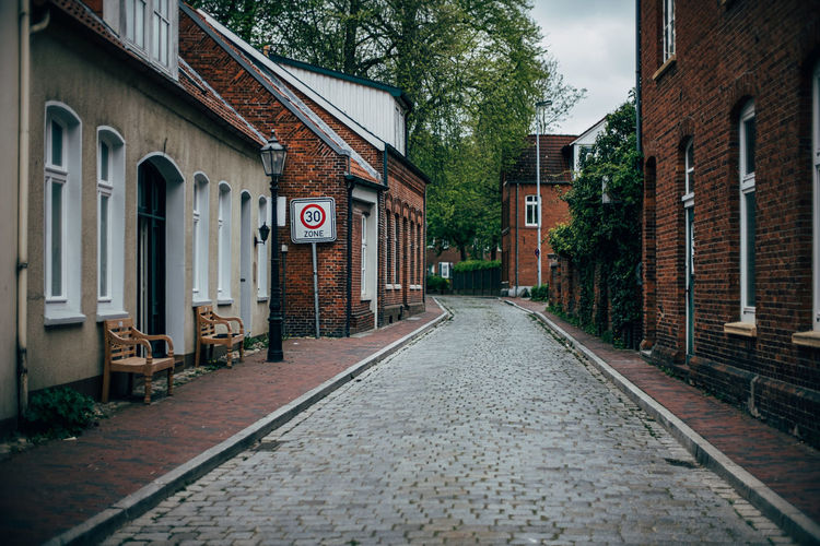 Scenic view of old street with cobblestones and brick wall houses in leer / germany