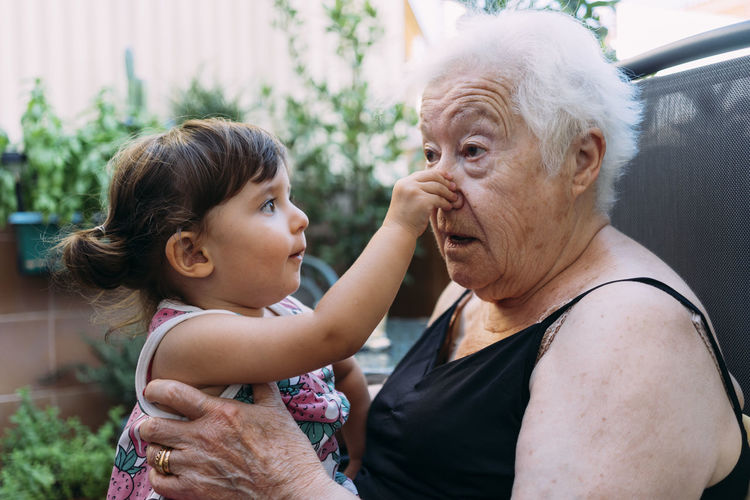 Grandmother and granddaughter playing together on the terrace