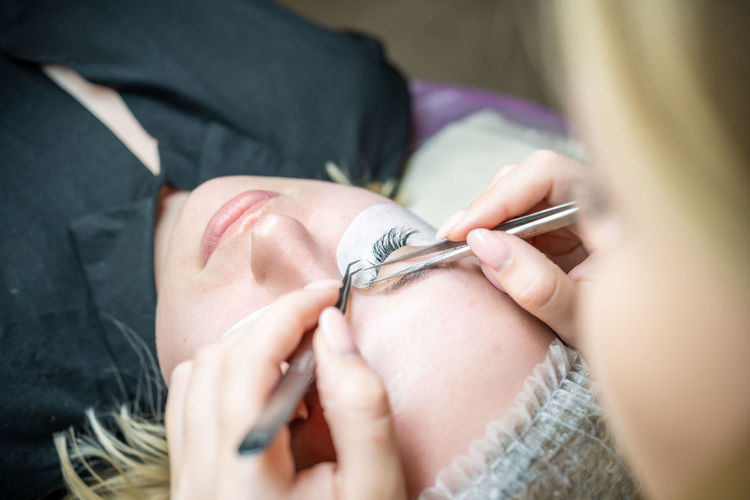 Female customer applying eye patch at salon