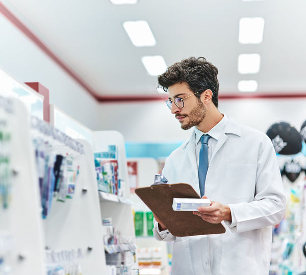 Male pharmacist doing inventory at store