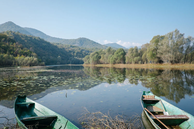 Boats moored in lake against sky