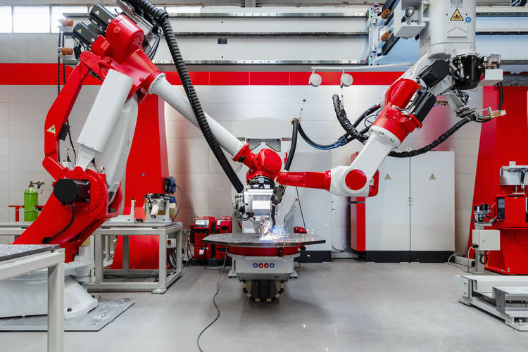 Automated industrial robots welding metal in factory