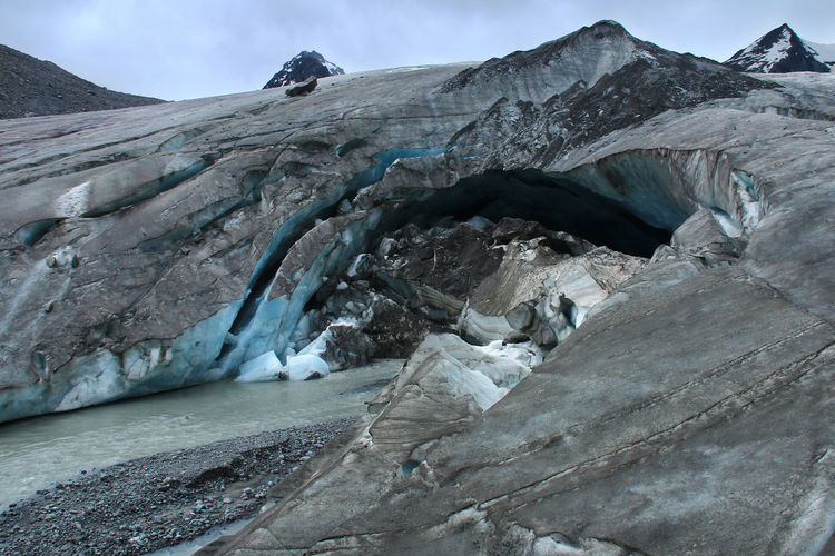 Sofia glacier with faults and cracks and a river flowing from it, altai, close
