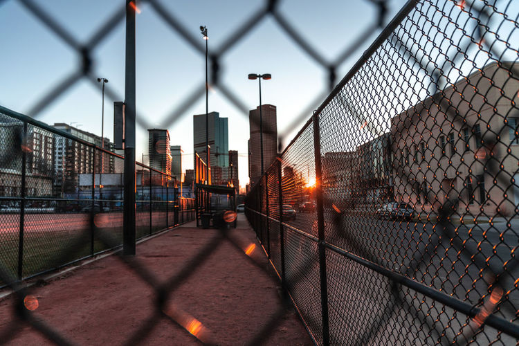 Full frame shot of chainlink fence against sky during sunset